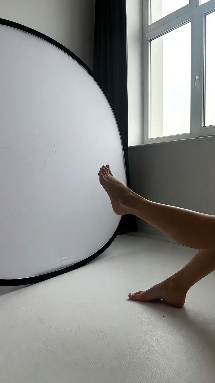 Setup de photographie de pieds près d'une fenêtre, soft daylight, réflecteur blanc, scène studio minimalist